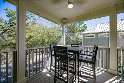 a screened porch with a table and chairs on it at Follow the Heron in Santa Rosa Beach