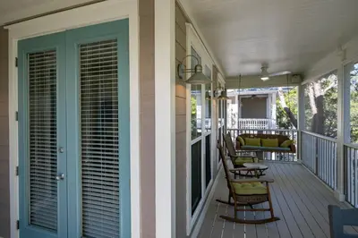 a porch with rocking chairs on a house at Follow the Heron in Santa Rosa Beach