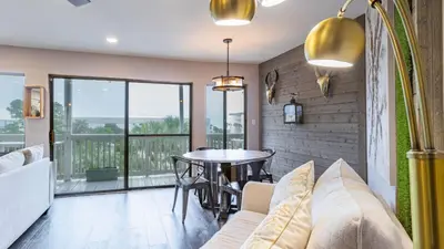 a living room with a couch and a table with chairs at Steps to the Beach Pool Hot Tub Renovated Retreat Sea Haven by AvantStay in Santa Rosa Beach