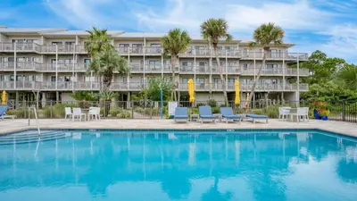 a hotel with a swimming pool in front of a building at Steps to the Beach Pool Hot Tub Renovated Retreat Sea Haven by AvantStay in Santa Rosa Beach