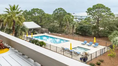 a view of the pool from the balcony of a hotel at Steps to the Beach Pool Hot Tub Renovated Retreat Sea Haven by AvantStay in Santa Rosa Beach