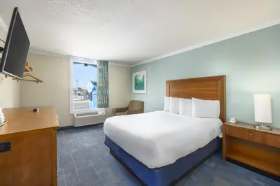 a hotel room with a large bed and a window at Beachside Resort Panama City Beach in Panama City Beach