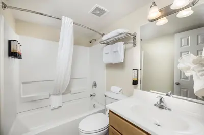a bathroom with a sink and a toilet and a mirror at Beachside Resort Panama City Beach in Panama City Beach