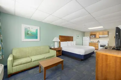 a hotel room with a bed and a bed and a couch at Beachside Resort Panama City Beach in Panama City Beach