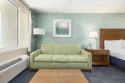 a bedroom with a couch and a bed and a chair at Beachside Resort Panama City Beach in Panama City Beach