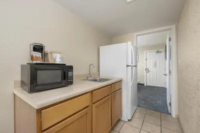 a kitchen with a microwave and a sink and a refrigerator at Beachside Resort Panama City Beach in Panama City Beach