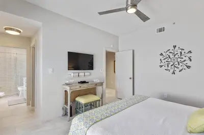 a bedroom with a bed and a desk with a tv at Grand Playa Unit 402 Gulf Front Condo in Santa Rosa Beach
