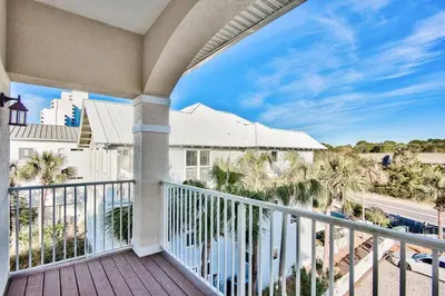 a balcony with a view of the beach and palm trees at Gulf Side Condo Seagrove Beach Community Pool in Santa Rosa Beach