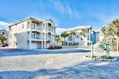 a large house with a sign in front of it at Gulf Side Condo Seagrove Beach Community Pool in Santa Rosa Beach