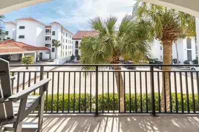 a balcony with a bench and palm trees at Palms of Seagrove D5, Steps to the Beach, Sleeps 4, Pool, 2 bikes and 5 mins from Seaside in Seagrove Beach