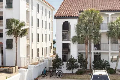 a group of palm trees in front of a building at Palms of Seagrove D5, Steps to the Beach, Sleeps 4, Pool, 2 bikes and 5 mins from Seaside in Seagrove Beach