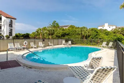 a swimming pool with lounge chairs at Palms of Seagrove D5, Steps to the Beach, Sleeps 4, Pool, 2 bikes and 5 mins from Seaside in Seagrove Beach