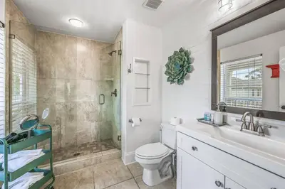 a bathroom with a shower and a toilet and a sink at Treasure Palms - Golf Cart- Bikes - Arcade- Peloton- Near Rosemary - Community Pool in Rosemary Beach