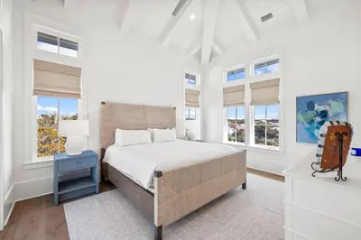 a white bedroom with a bed and windows at All Tide Up in Seacrest