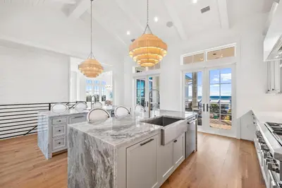 a kitchen with white counters and a large kitchen with windows at All Tide Up in Seacrest