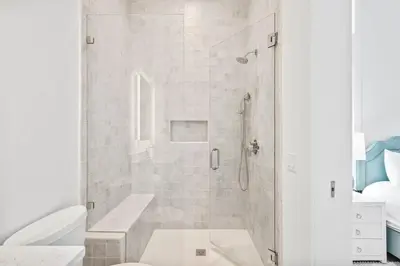a white bathroom with a shower and a toilet at All Tide Up in Seacrest