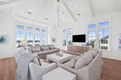 a living room with white furniture and a flat screen tv at All Tide Up in Seacrest