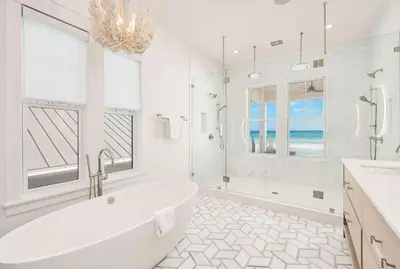 a white bathroom with a tub and a window at Costa Fortune in Inlet Beach