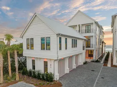 a white house with the ocean in the background at Costa Fortune in Inlet Beach
