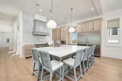 a kitchen with a large white table and chairs at Costa Fortune in Inlet Beach
