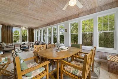 a dining room with a table and chairs and windows at 30A Beach House - The Hemingway by Panhandle Getaways in Seacrest