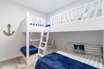 a bedroom with two bunk beds and a ladder at 30A Top Rated! Heated Resort Pool+Golf Cart+Bikes+Bunks+Beach Gear in Watersound Beach