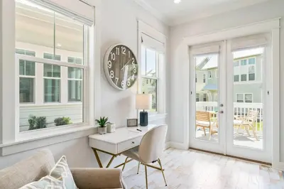 a living room with a table and a clock on the wall at 30A Top Rated! Heated Resort Pool+Golf Cart+Bikes+Bunks+Beach Gear in Watersound Beach