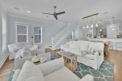 a living room with white furniture and a staircase at Anna's Beach House Walk-Out To 30A in Seacrest- Pet-Friendly in Rosemary Beach