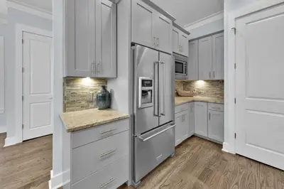 a kitchen with white cabinets and a refrigerator at Anna's Beach House Walk-Out To 30A in Seacrest- Pet-Friendly in Rosemary Beach