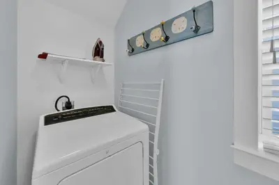 a white kitchen with a stove top oven next to a window at Anna's Beach House Walk-Out To 30A in Seacrest- Pet-Friendly in Rosemary Beach