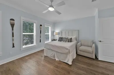 a white bedroom with a bed and a chair at Anna's Beach House Walk-Out To 30A in Seacrest- Pet-Friendly in Rosemary Beach