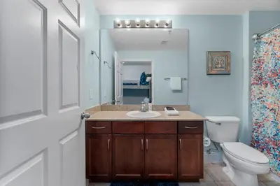 a bathroom with a sink and a toilet and a mirror at Nautical Nest at Laketown Wharf #1019 by Nautical Properties in Panama City Beach