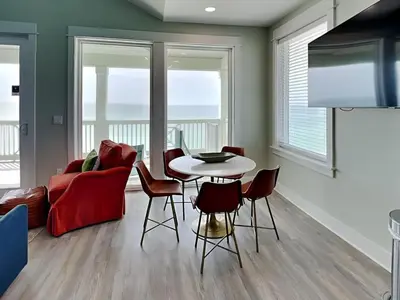 a living room with a red couch and a table and chairs at Breezy Beach in Panama City Beach