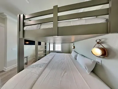 two bunk beds in a room with a bed at Breezy Beach in Panama City Beach