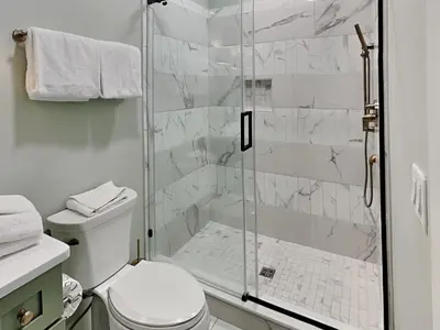 a bathroom with a toilet and a glass shower at Breezy Beach in Panama City Beach