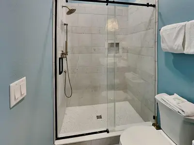 a shower with a glass door in a bathroom at Breezy Beach in Panama City Beach