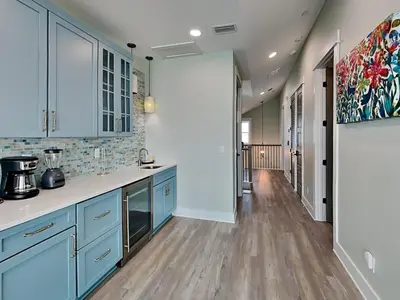 a kitchen with blue cabinets and a hardwood floor at Breezy Beach in Panama City Beach