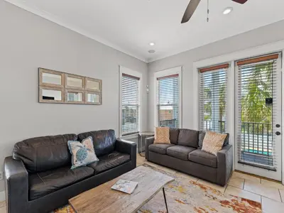 a living room with two leather couches and a table at Salty Beach in Panama City Beach