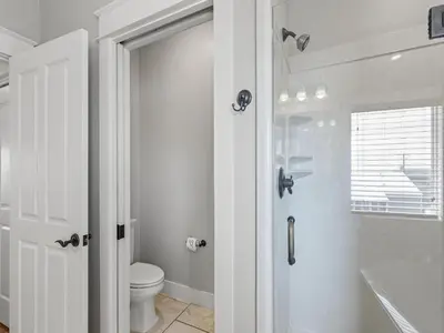 a white bathroom with a toilet and a shower at Salty Beach in Panama City Beach