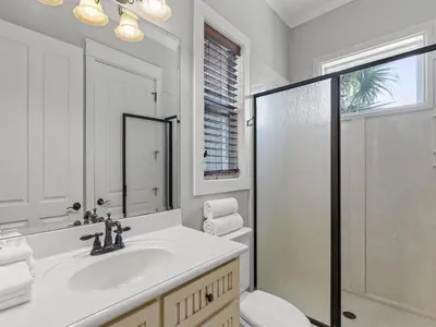 a white bathroom with a sink and a shower at Salty Beach in Panama City Beach