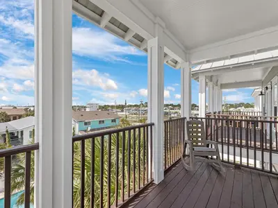 a balcony with a bench and a view of the ocean at Salty Beach in Panama City Beach