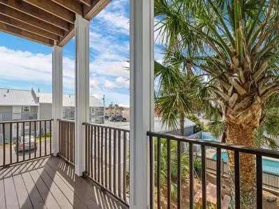 a view from the balcony of a condo with a palm tree at Salty Beach in Panama City Beach