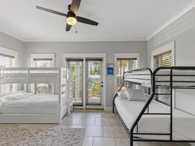 a bedroom with two bunk beds and a ceiling fan at Salty Beach in Panama City Beach
