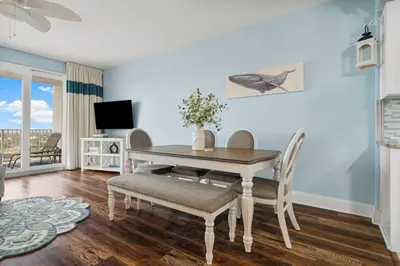 a dining room with a table and chairs and a television at Laketown Wharf #1734 by Nautical Properties in Panama City Beach