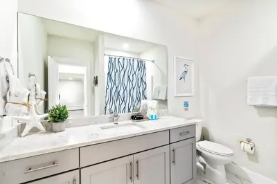 a bathroom with a sink and a toilet and a mirror at Beautiful Home .5mi to Beach SLPS 14! Bikes, 3rd Floor Bunk/Game Room - 2 King Bedrooms in Inlet Beach