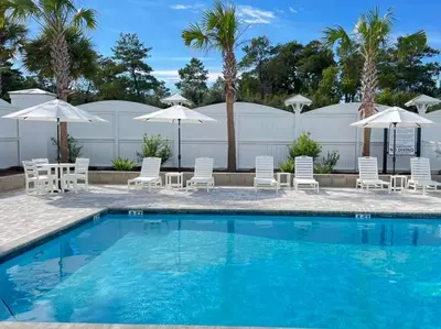a swimming pool with chairs and umbrellas at Beautiful Home .5mi to Beach SLPS 14! Bikes, 3rd Floor Bunk/Game Room - 2 King Bedrooms in Inlet Beach