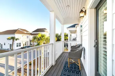 a porch with a chair and a view of the ocean at Beautiful Home .5mi to Beach SLPS 14! Bikes, 3rd Floor Bunk/Game Room - 2 King Bedrooms in Inlet Beach