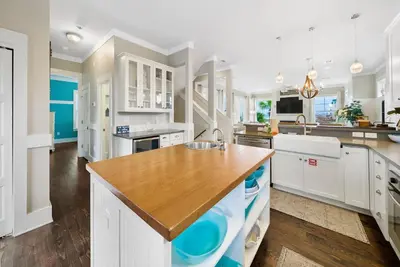 a kitchen with white cabinets and a wooden counter top at La Luna in Santa Rosa Beach
