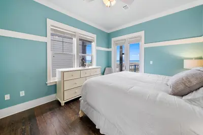 a bedroom with blue walls and a bed and a window at La Luna in Santa Rosa Beach
