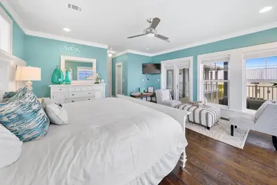 a bedroom with a white bed and blue walls at La Luna in Santa Rosa Beach